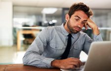Shot of a young businessman cheering while using a laptop at his desk in an office